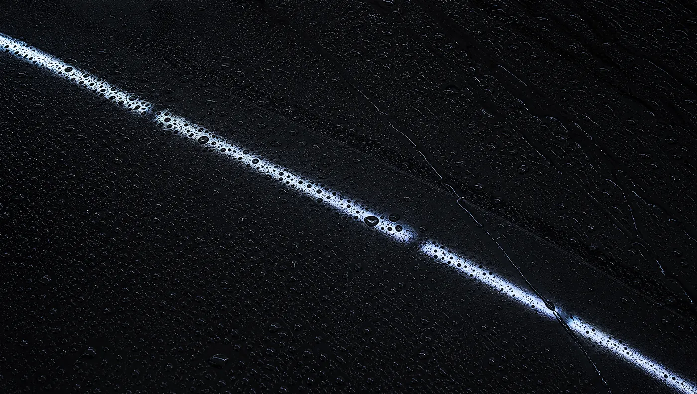 An LED strip reflected in corrected black paint